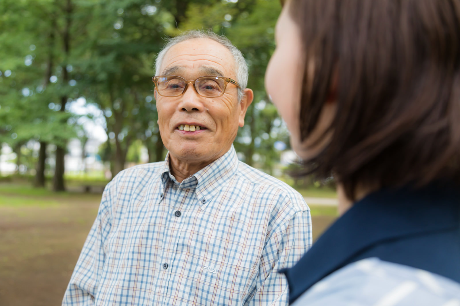 公園でご利用者と笑顔で会話するてとてケアのスタッフ