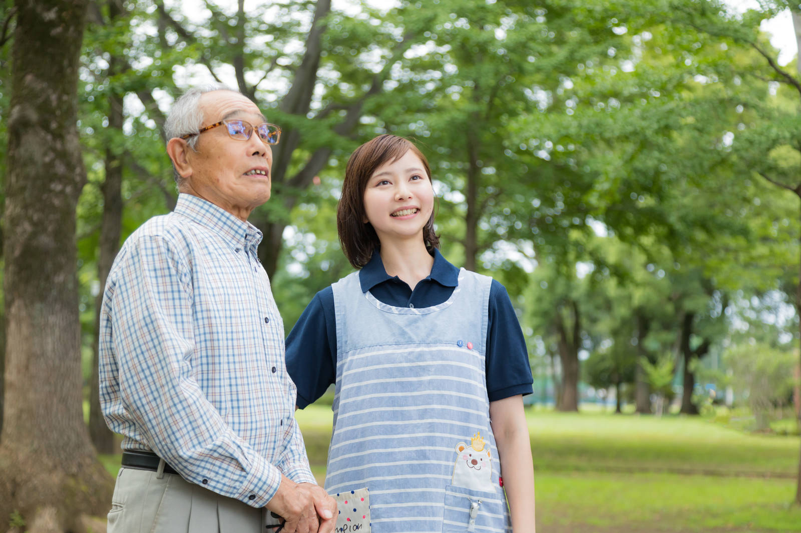 公園を散歩する利用者に付き添うスタッフの外出支援