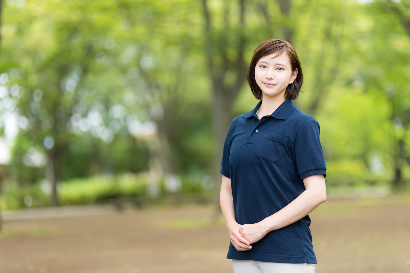 公園で笑顔を見せるスタッフのポートレート写真